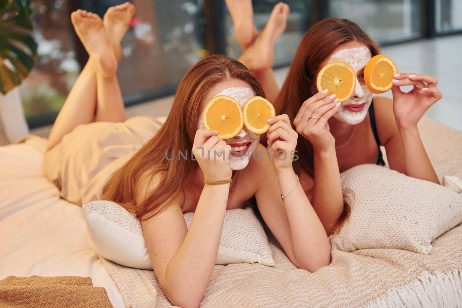 White clearing mask on faces. Two happy women is at a bachelorette party together.