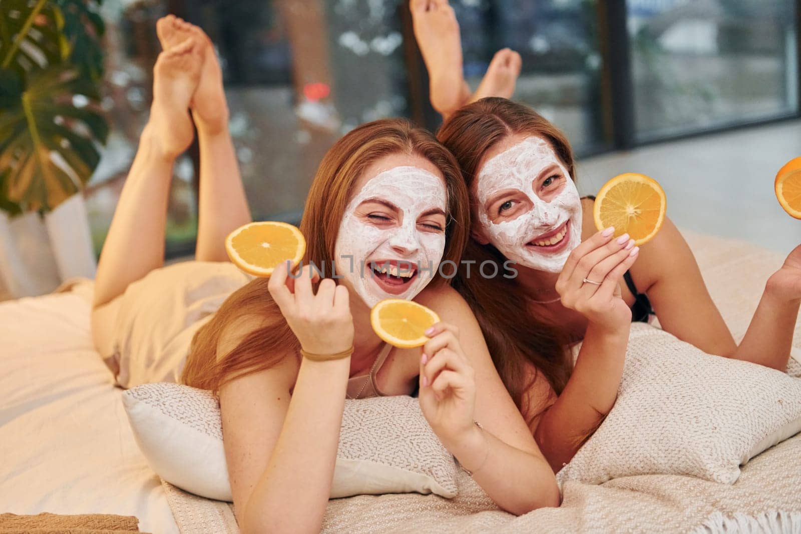 White clearing mask on faces. Two happy women is at a bachelorette party together.