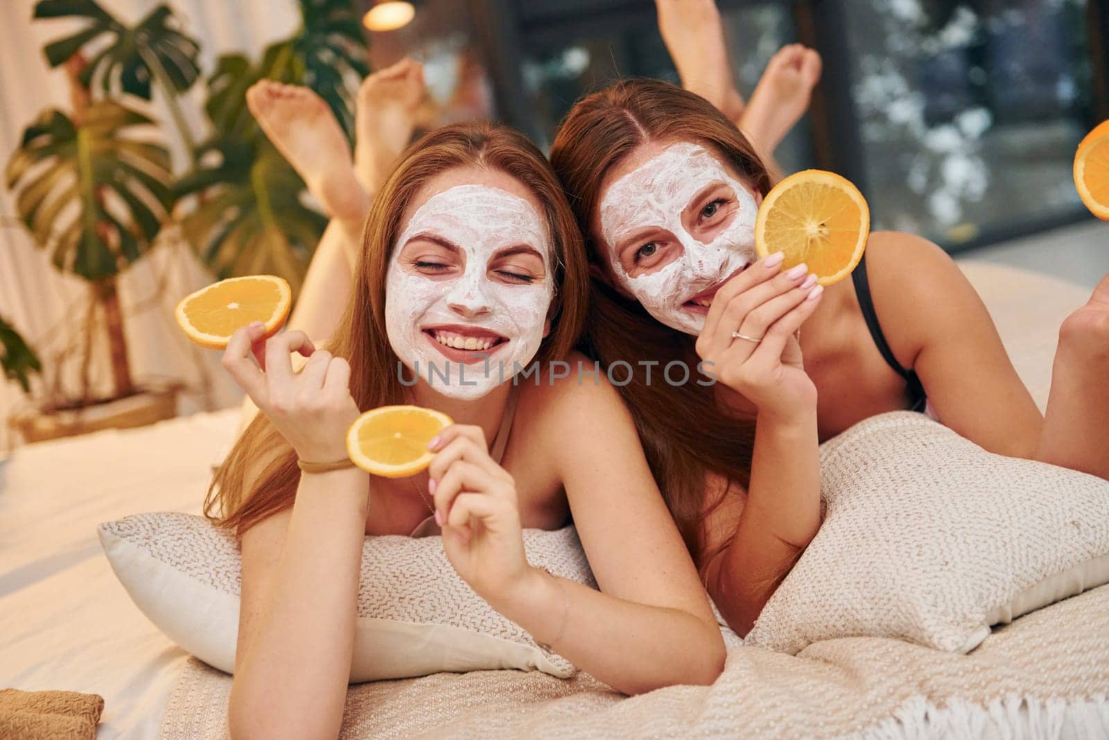 White clearing mask on faces. Two happy women is at a bachelorette party together.