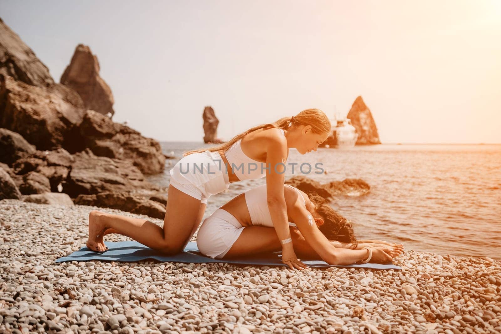 Woman sea yoga. Back view of free calm happy satisfied woman with long hair standing on top rock with yoga position against of sky by the sea. Healthy lifestyle outdoors in nature, fitness concept.