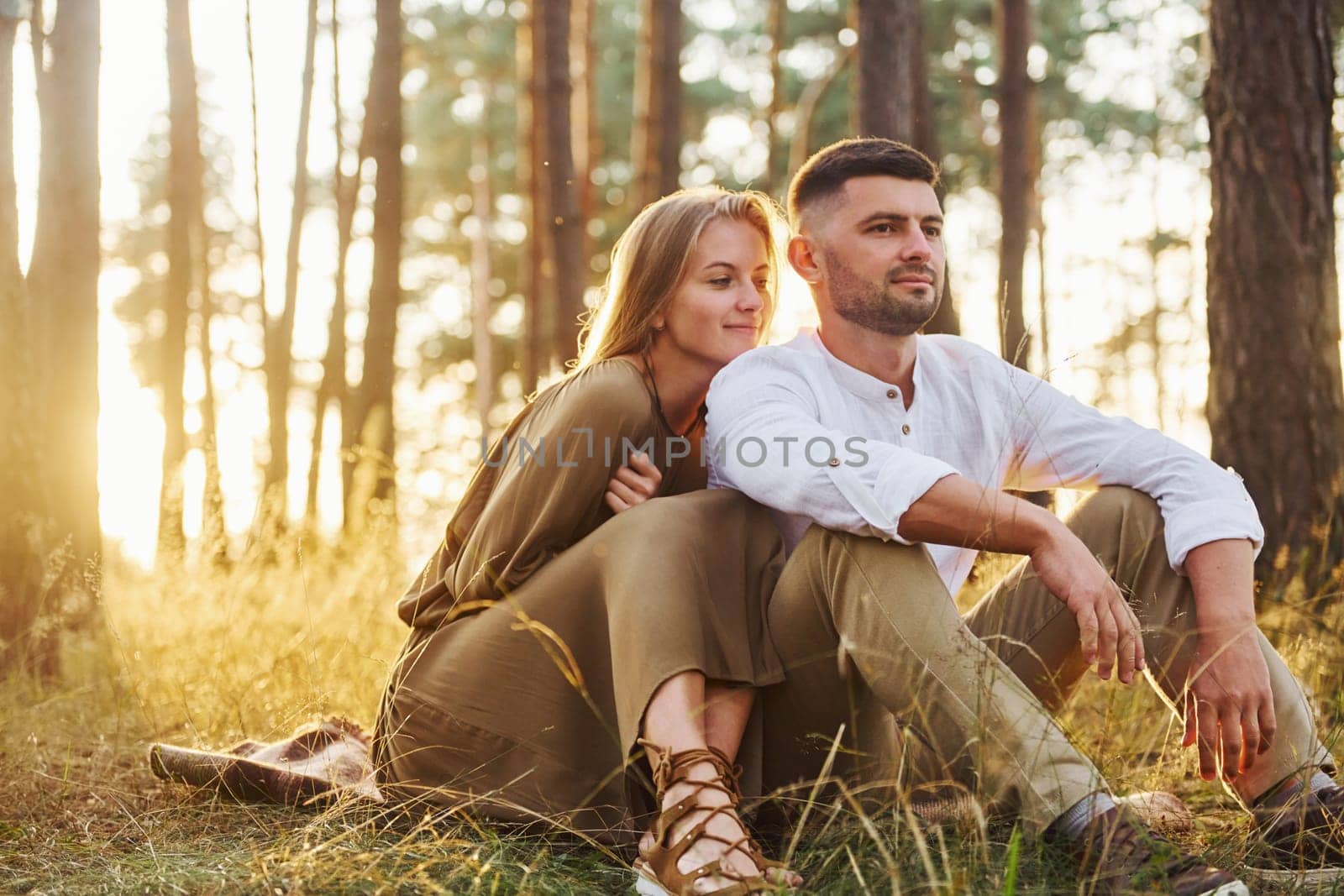 Resting in the forest. Happy couple is outdoors at daytime by Standret