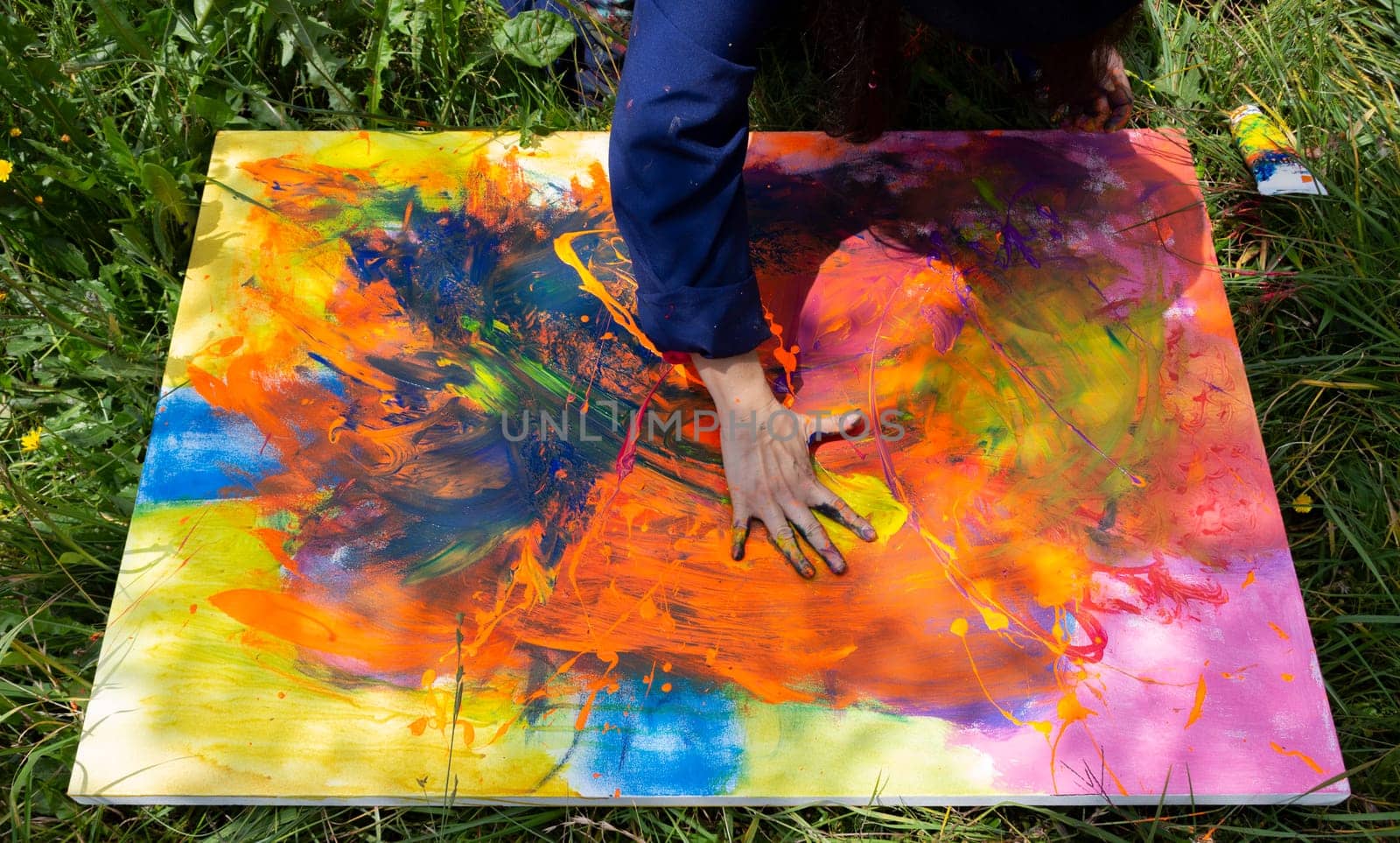 The art of colour, Close-up of the hands of a painter adding the finishing touches to a vibrant abstract painting. High quality photo