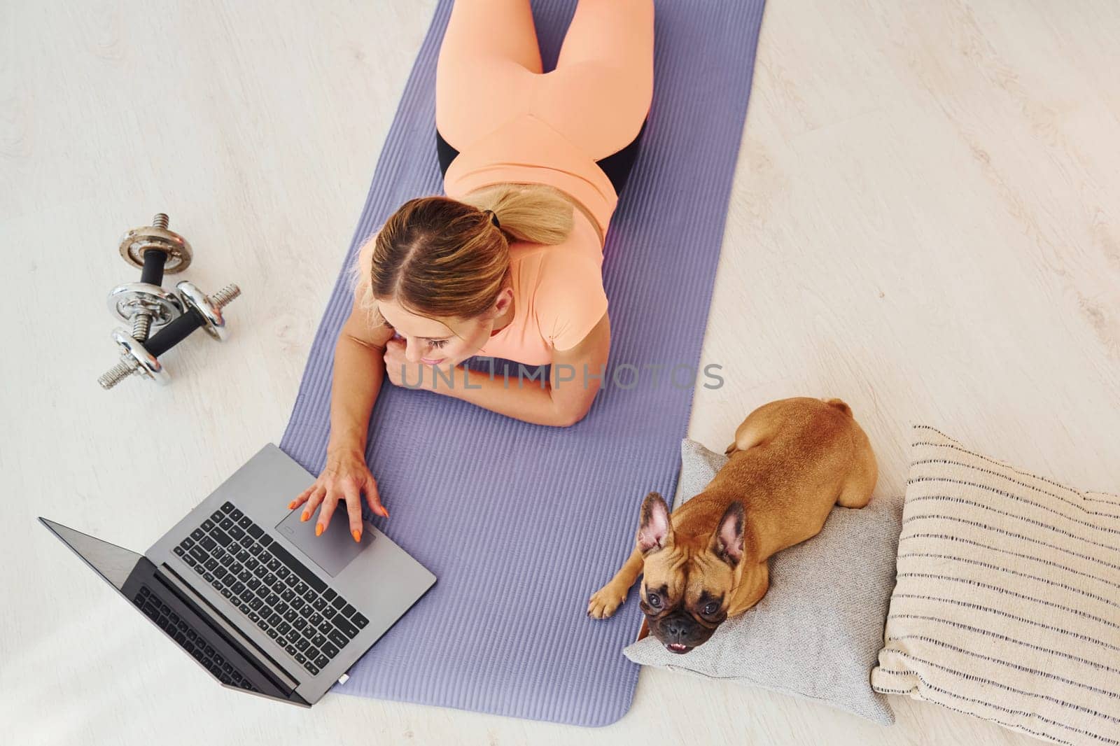 Top view of woman with pug dog and laptop that is at home at daytime by Standret