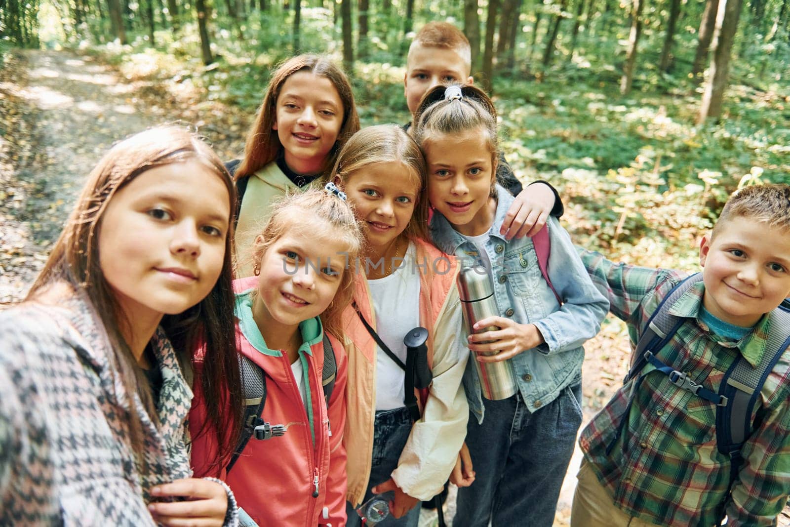 Making selfie. Kids in green forest at summer daytime together by Standret