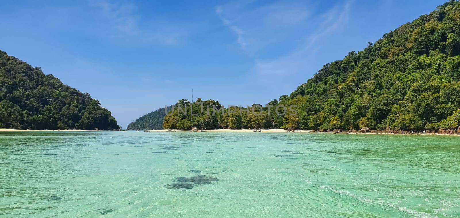 Scenic view of Koh Mak Island's peaceful white sand beach and crystal clear turquoise sea water bay with tropical tree