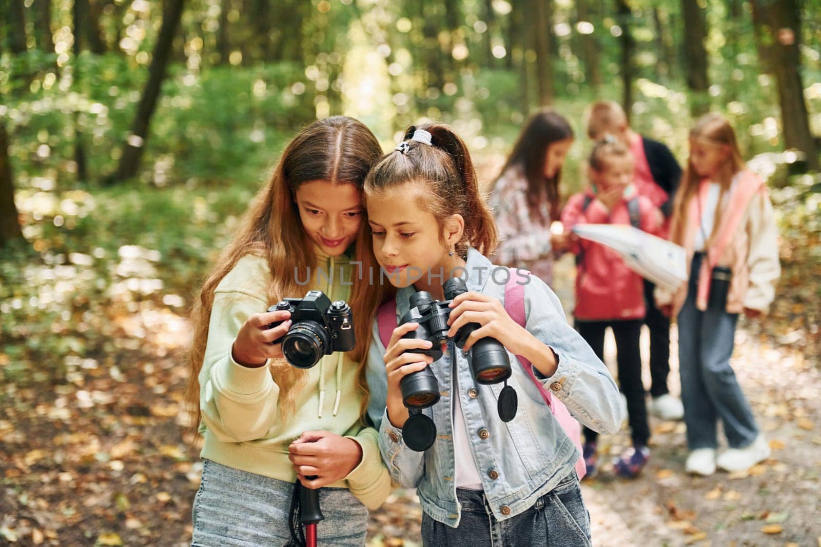 Conception of tourism. Kids in green forest at summer daytime together by Standret