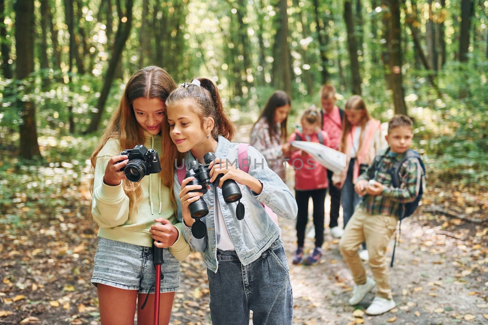 Conception of tourism. Kids in green forest at summer daytime together by Standret