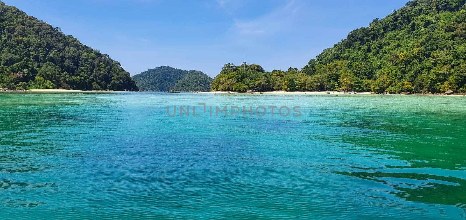 Scenic view of Koh Mak Island's peaceful white sand beach and crystal clear turquoise sea water bay with tropical tree