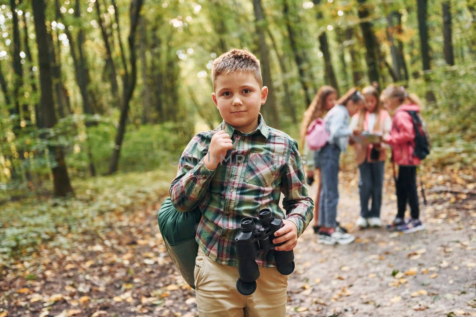 Conception of hiking. Kids in green forest at summer daytime together.