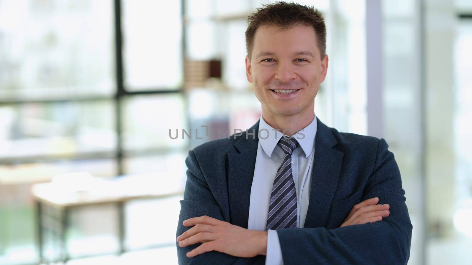 Portrait of smiling successful businessman with arms crossed. Success in business concept