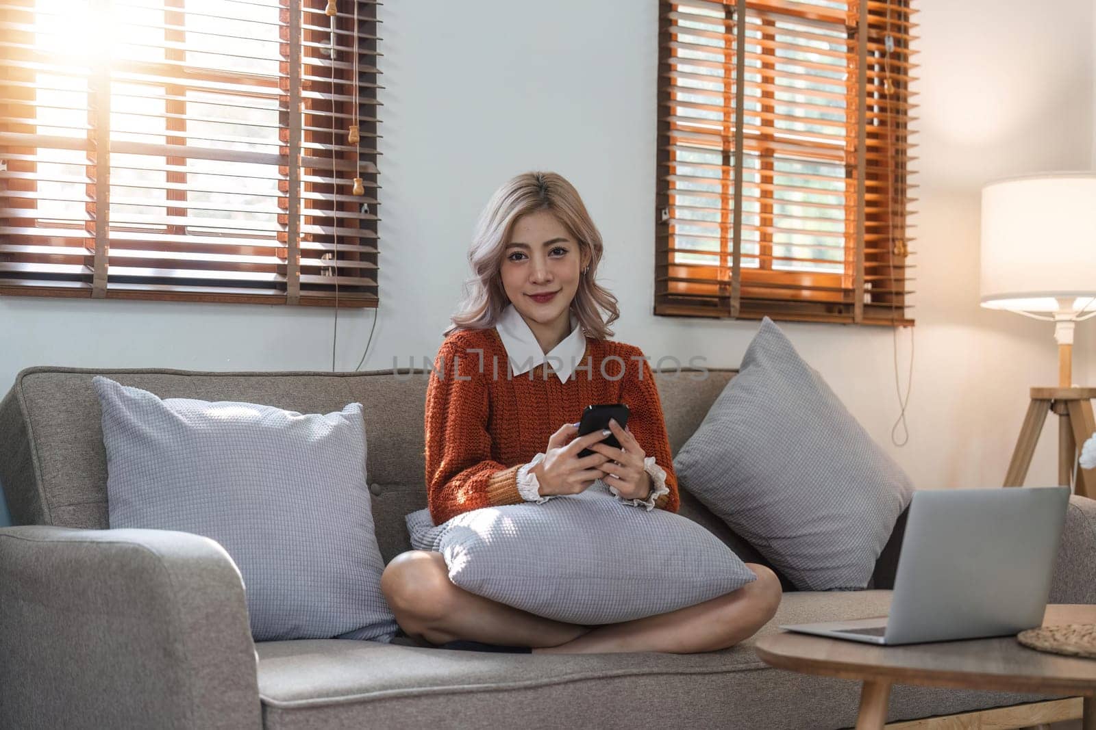 woman beautiful happy young woman resting on comfortable sofa, using cellphone application, web surfing useful information, playing games, shopping online by nateemee