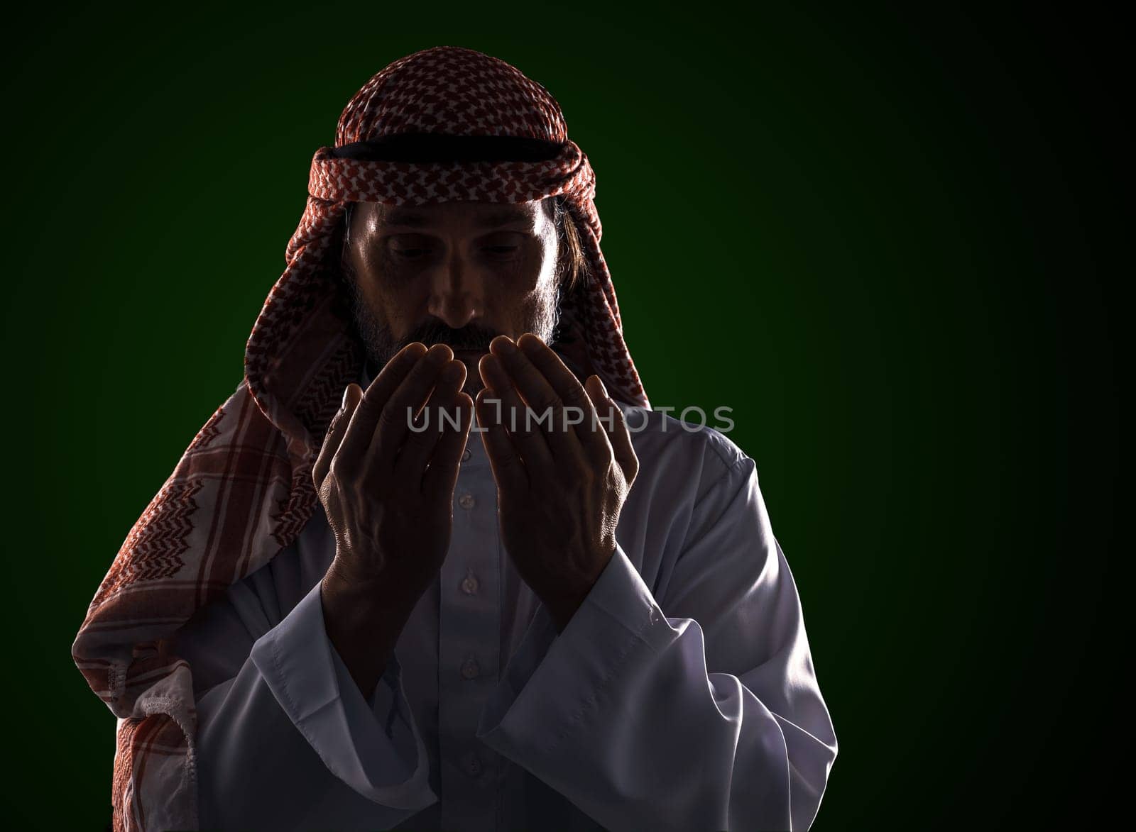 Arab man in prayer with his palms in front of his face. It conveys the devotion and spirituality inherent in Islamic culture by LipikStockMedia