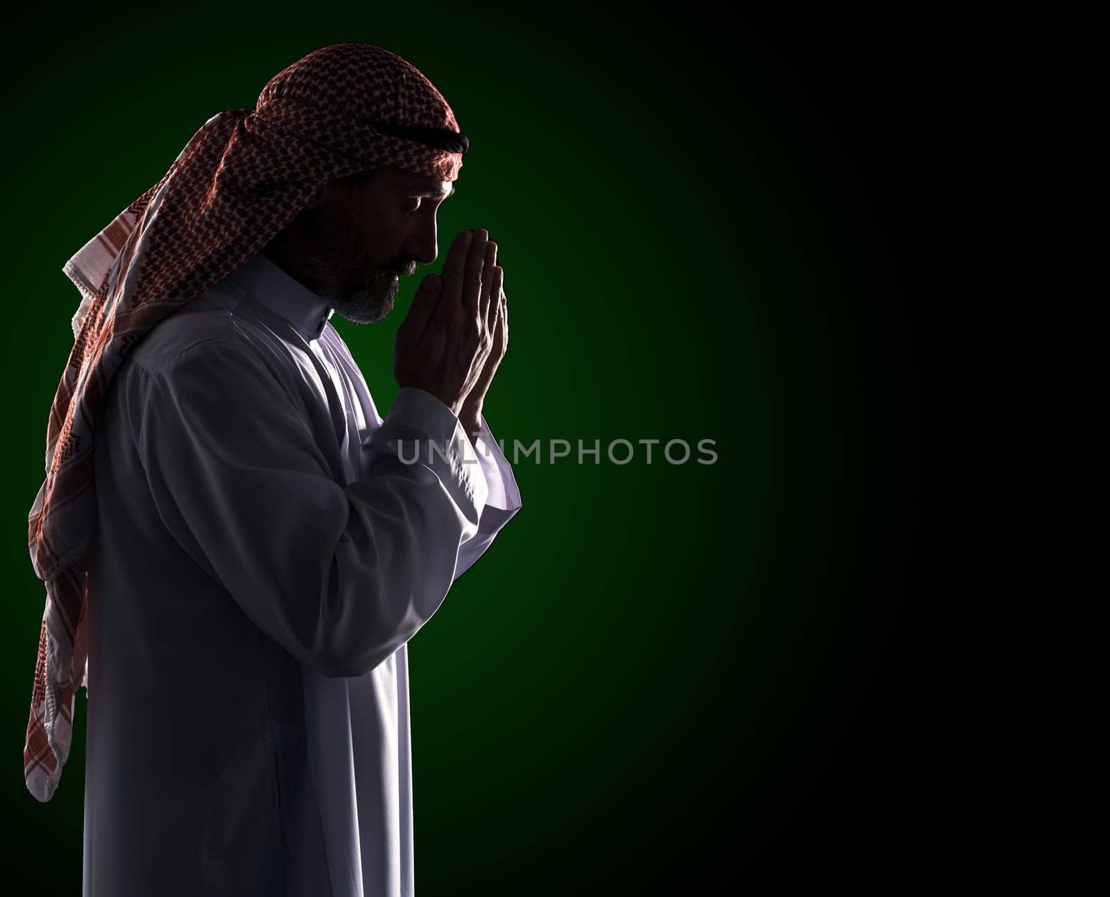 Islamic prayer ritual. Arab Man in Profile Holding Palms in Front of Face, Copy Space by LipikStockMedia