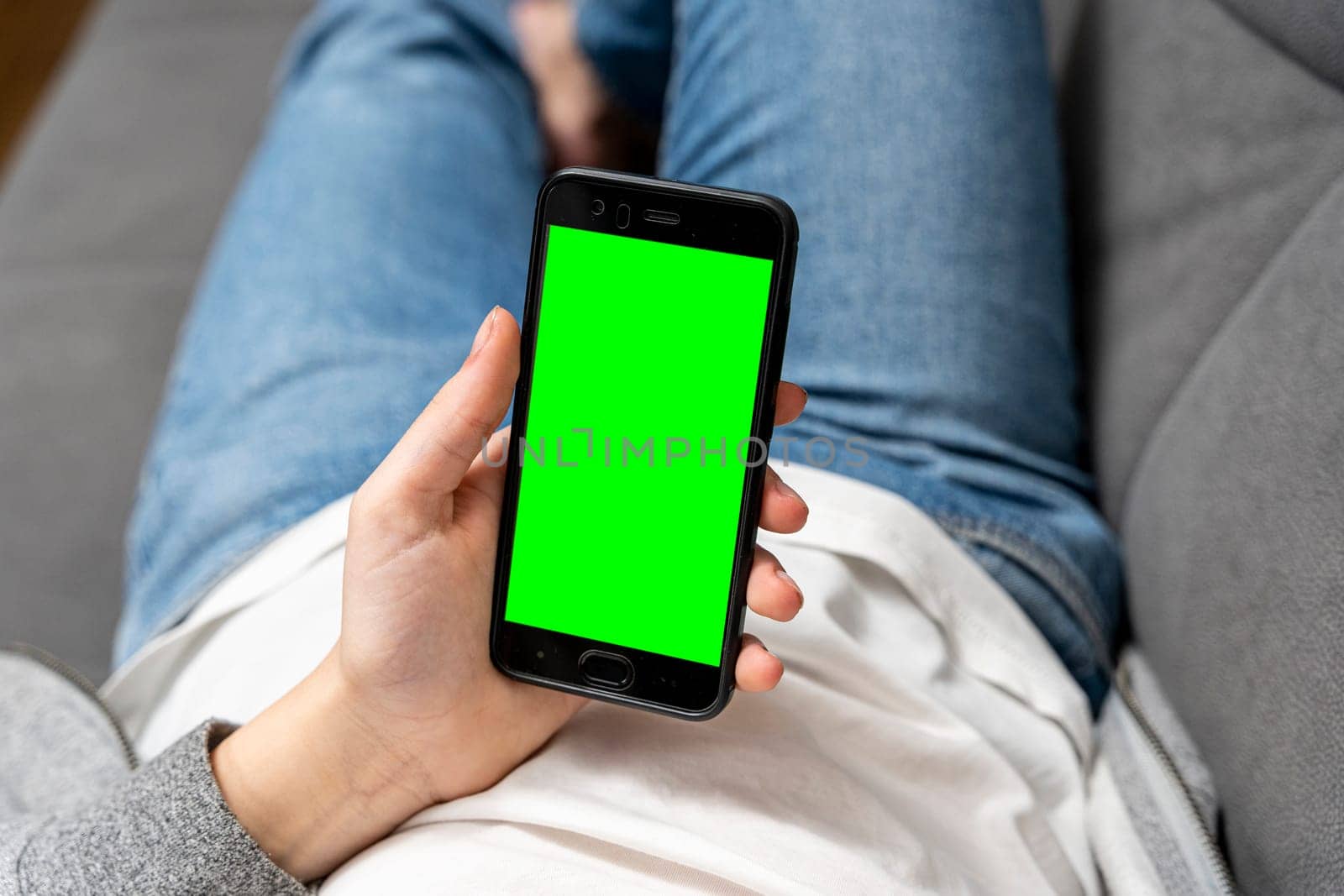 girl uses a smartphone with a green screen while sitting on the couch by audiznam2609