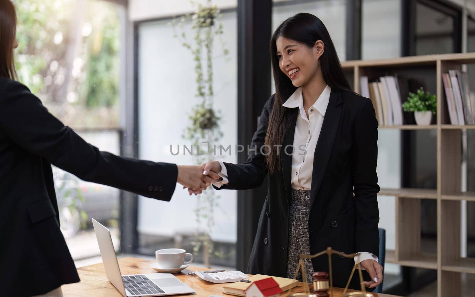 Lawyer business women shaking hands with clients, after finishing up a Consulting for insurance rent house. concept of home protection.