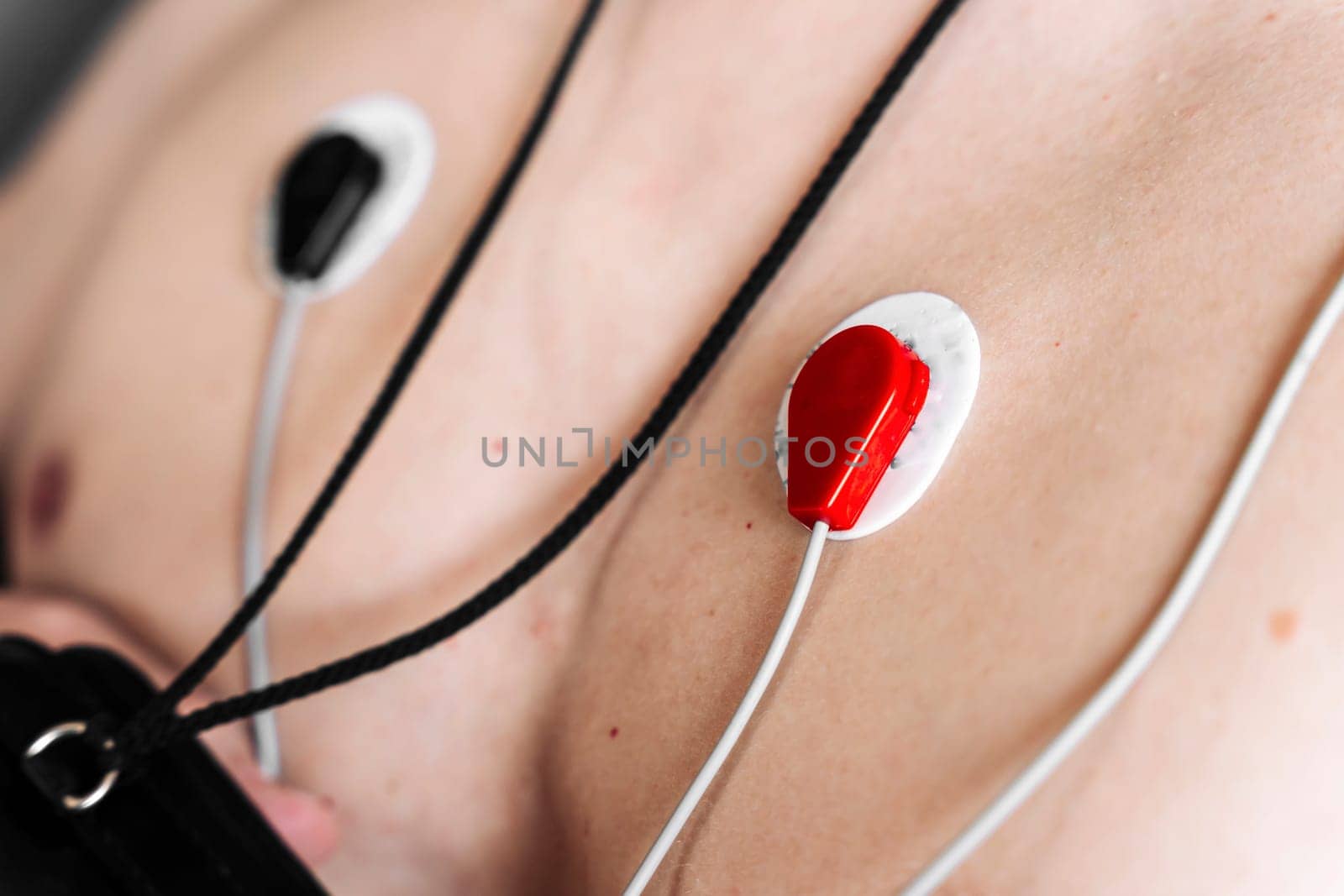 Holter Heart Monitor. close-up of sensors. A man wearing portable holter monitor device. Recording cardiogram for 24 hours. Arrhythmia. diagnosis of cardiac activity. prevention, monitoring, heart problems