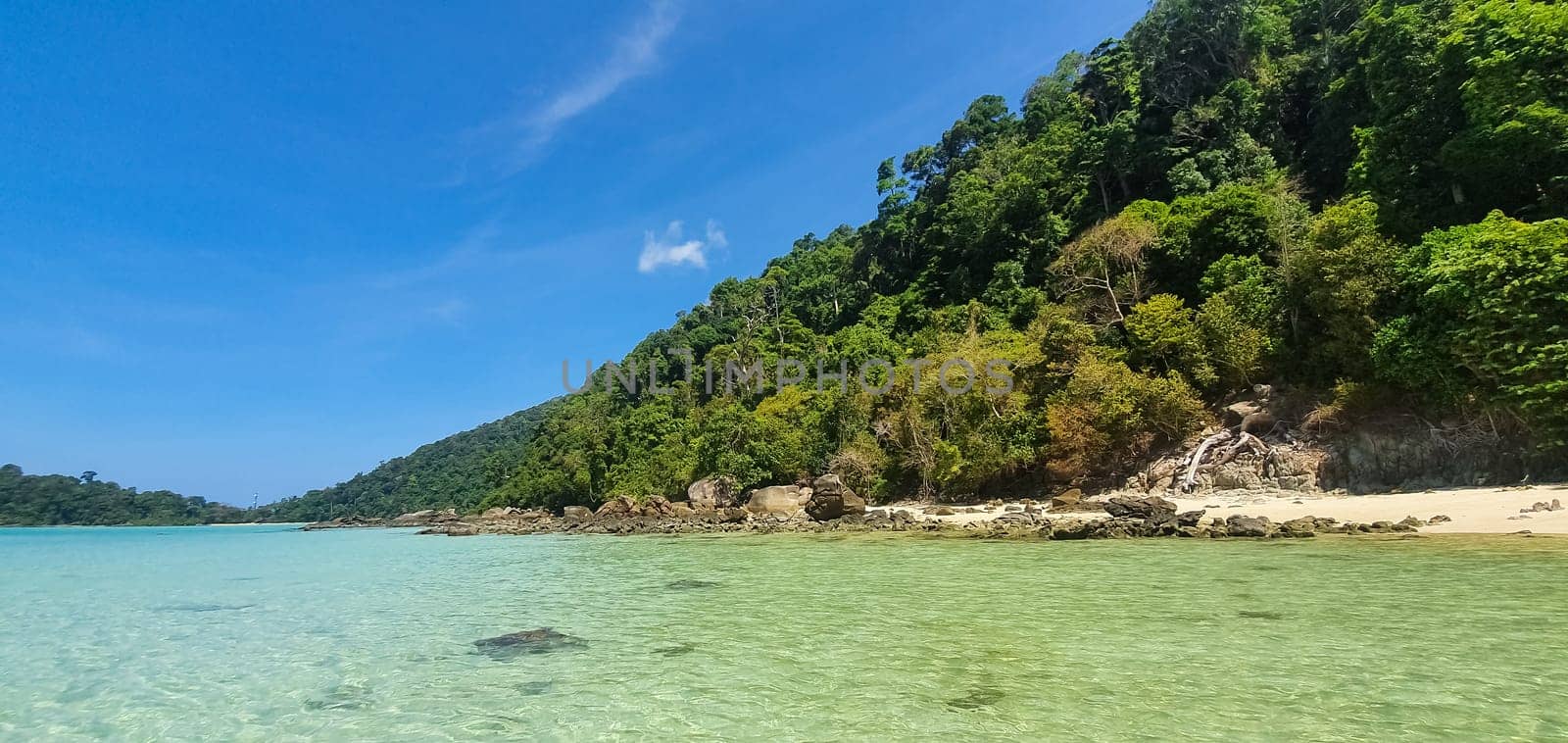 Emerald sea water and beautiful natural rocky seashore. Summer vacation concept