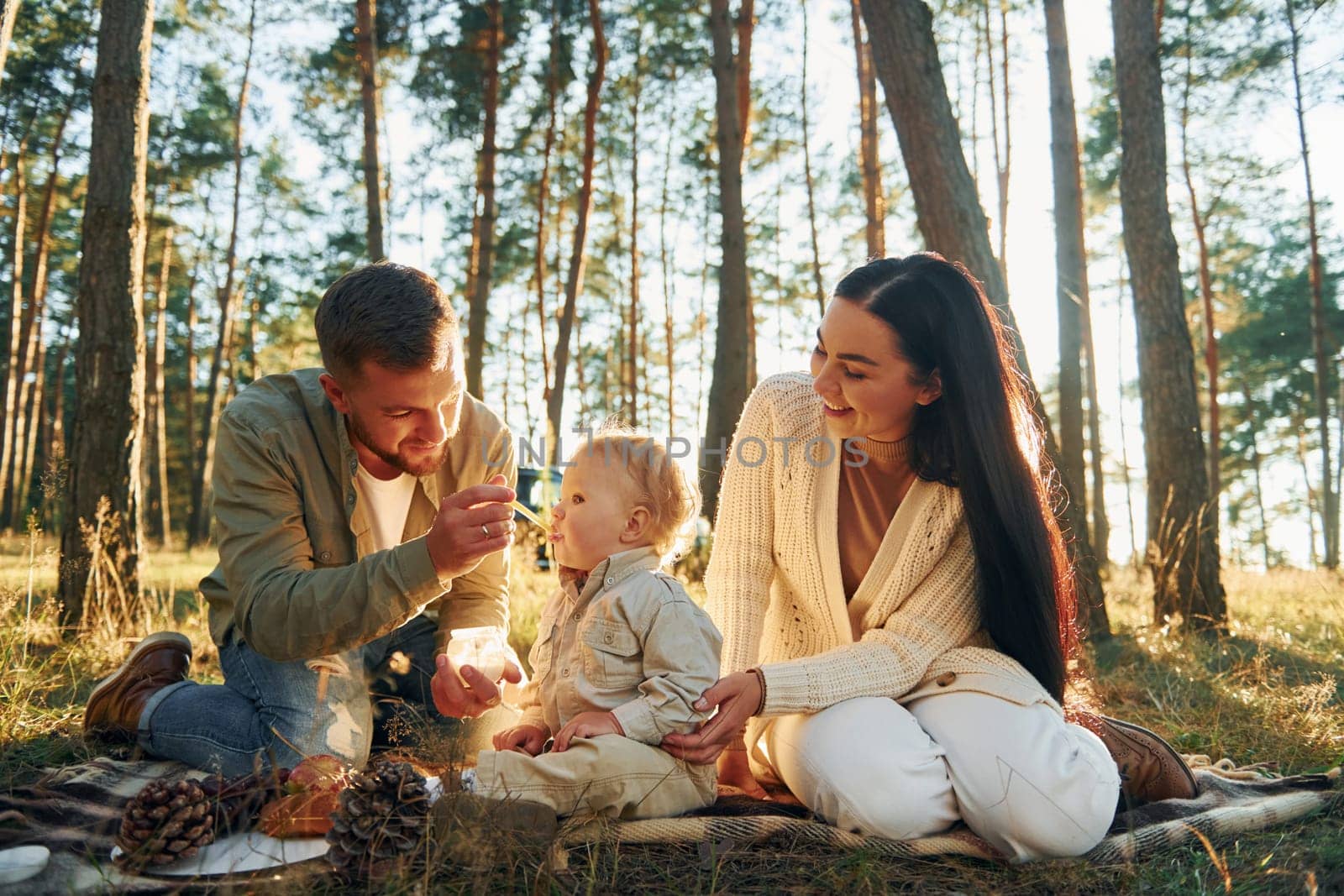In the forest. Happy family of father, mother and little daughter.