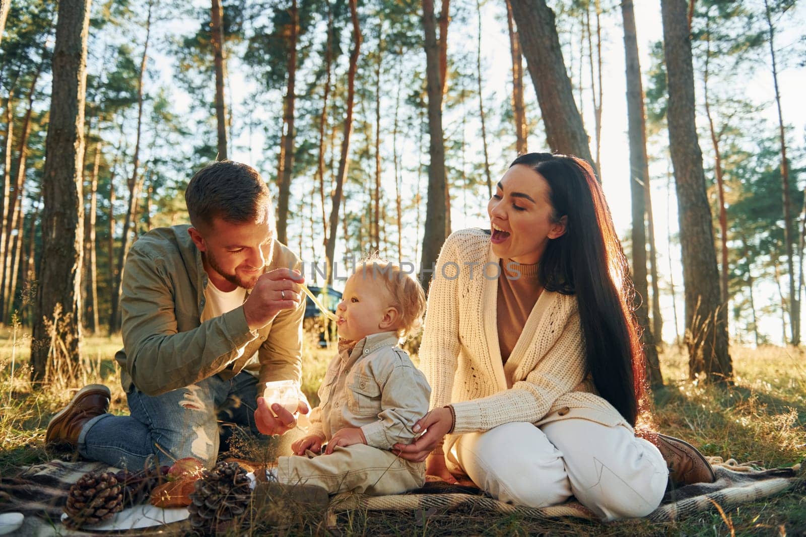 In the forest. Happy family of father, mother and little daughter.