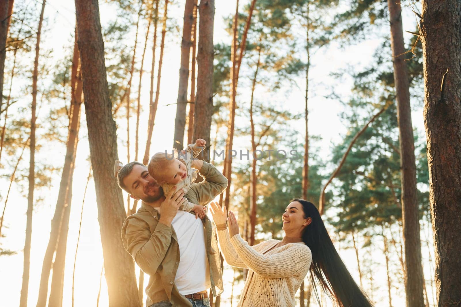 Joy and happiness. Family of father, mother and little daughter is in the forest.