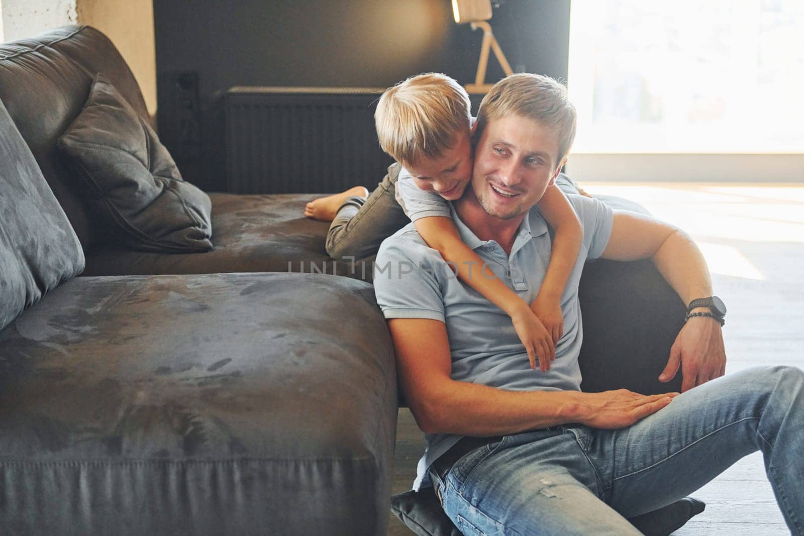 Having fun. Father and son is indoors at home together.