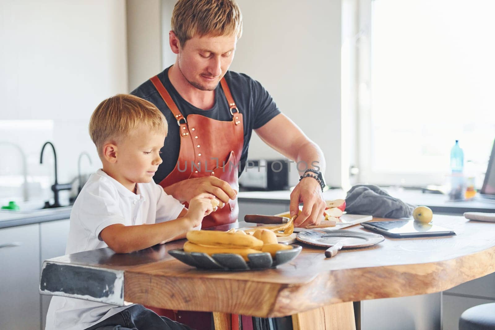 Conception of culinary. Father and son is indoors at home together.