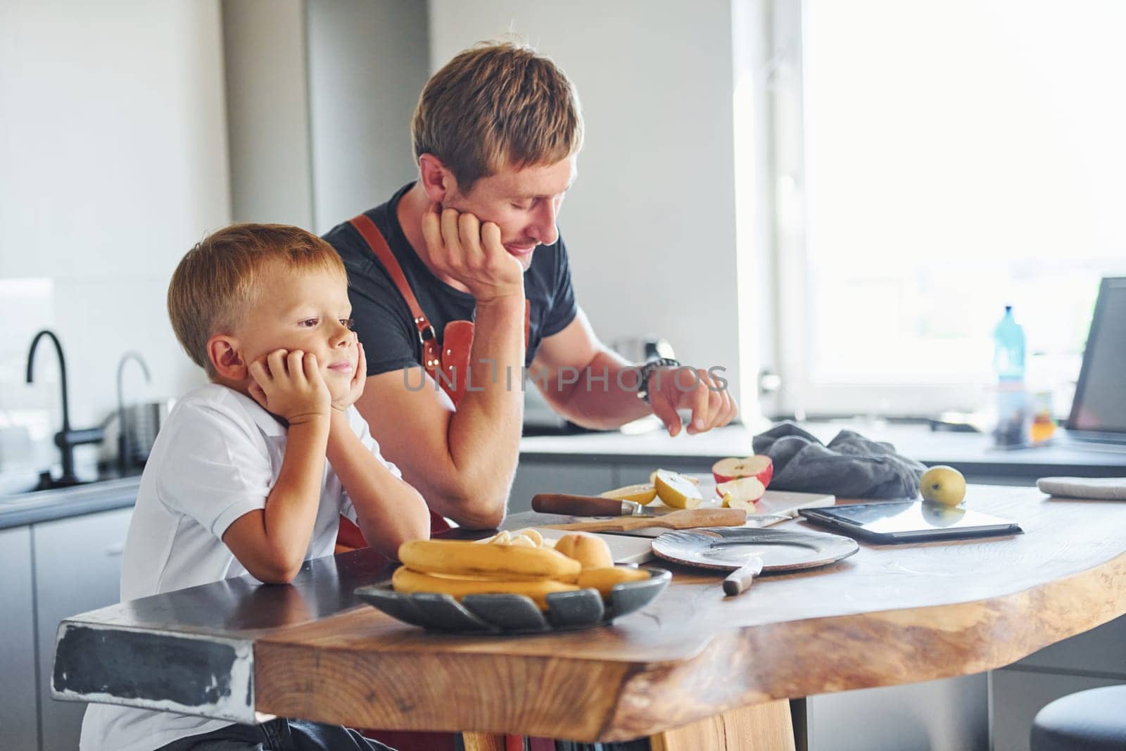 Conception of culinary. Father and son is indoors at home together.