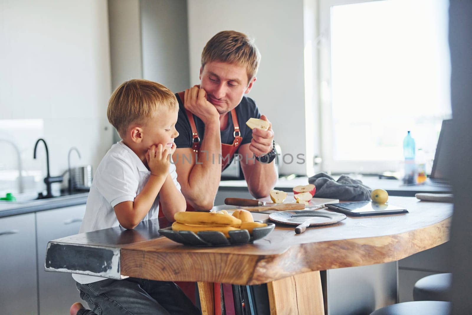 Conception of culinary. Father and son is indoors at home together.