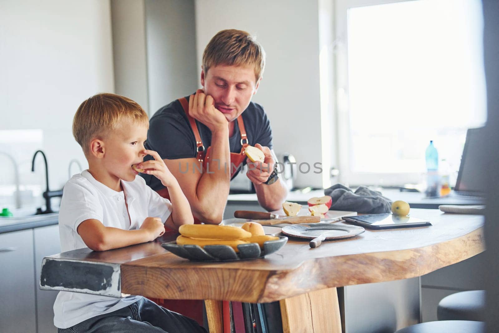Conception of culinary. Father and son is indoors at home together.