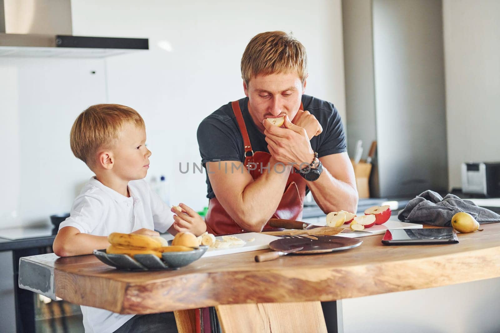 Conception of culinary. Father and son is indoors at home together.