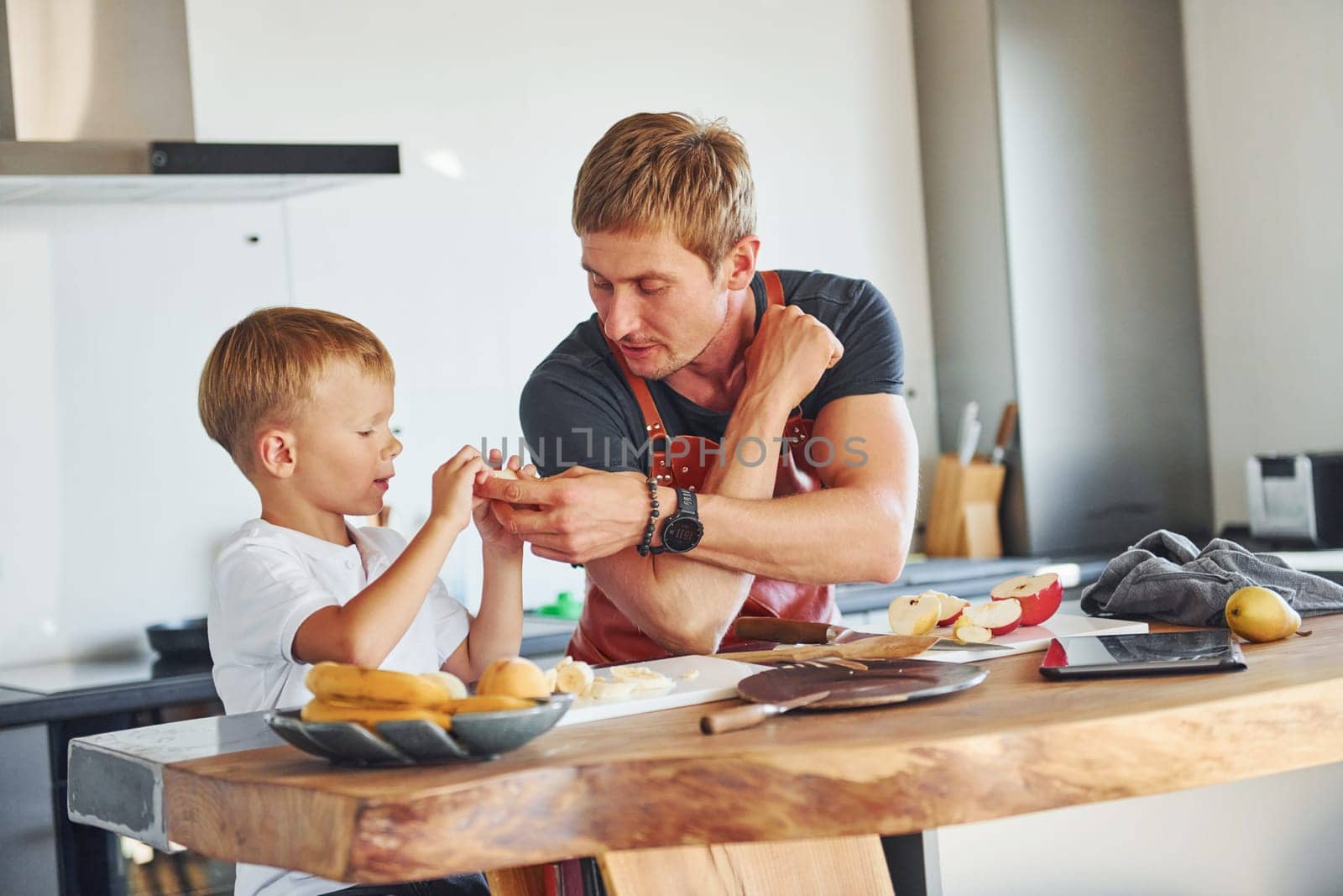 Healthy food. Father and son is indoors at home together.