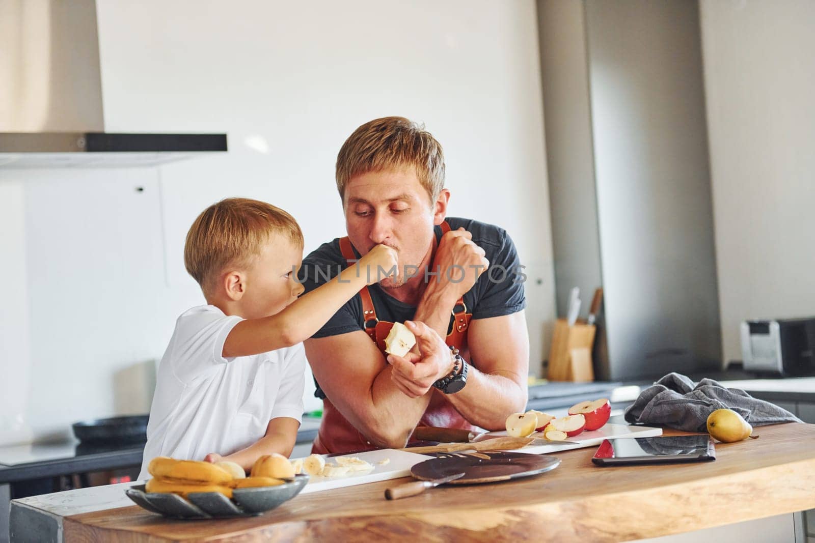 Healthy food. Father and son is indoors at home together.