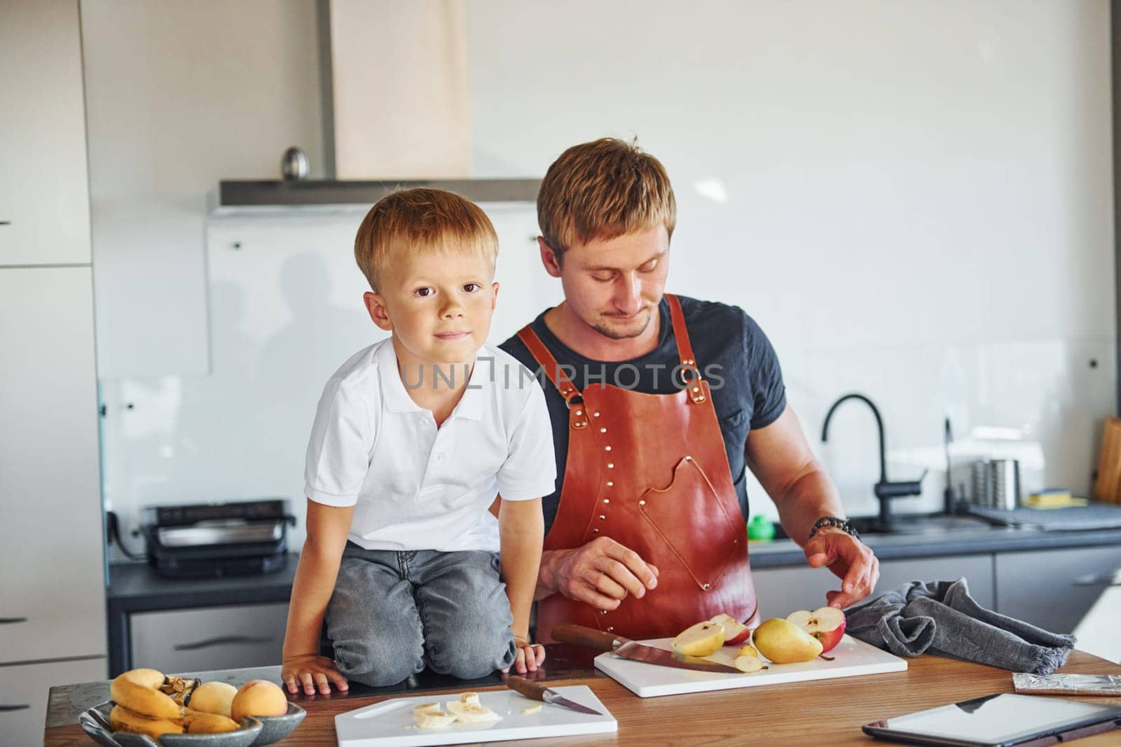 Healthy food. Father and son is indoors at home together by Standret