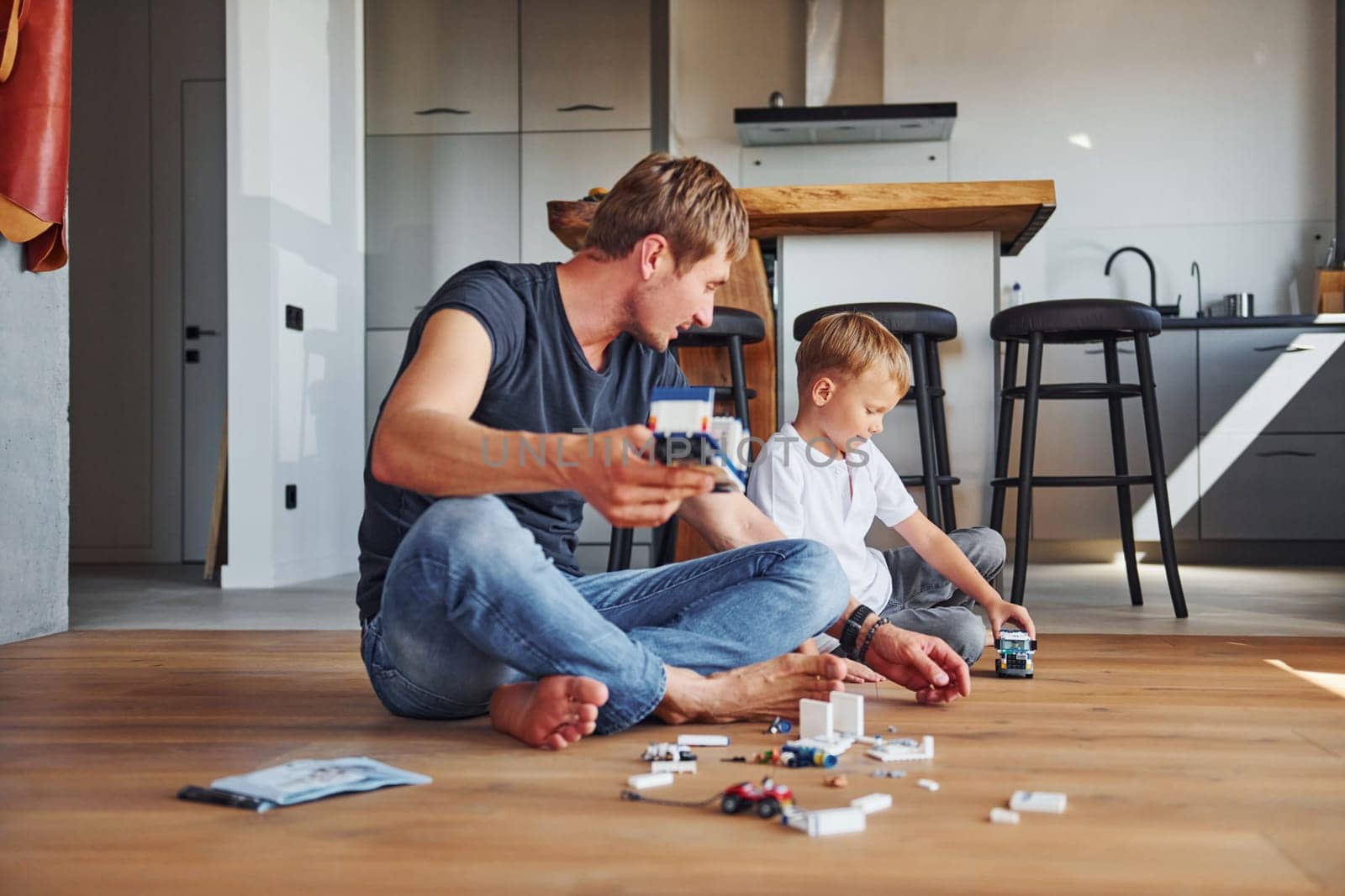 Weekend rest. Father and son is indoors at home together by Standret