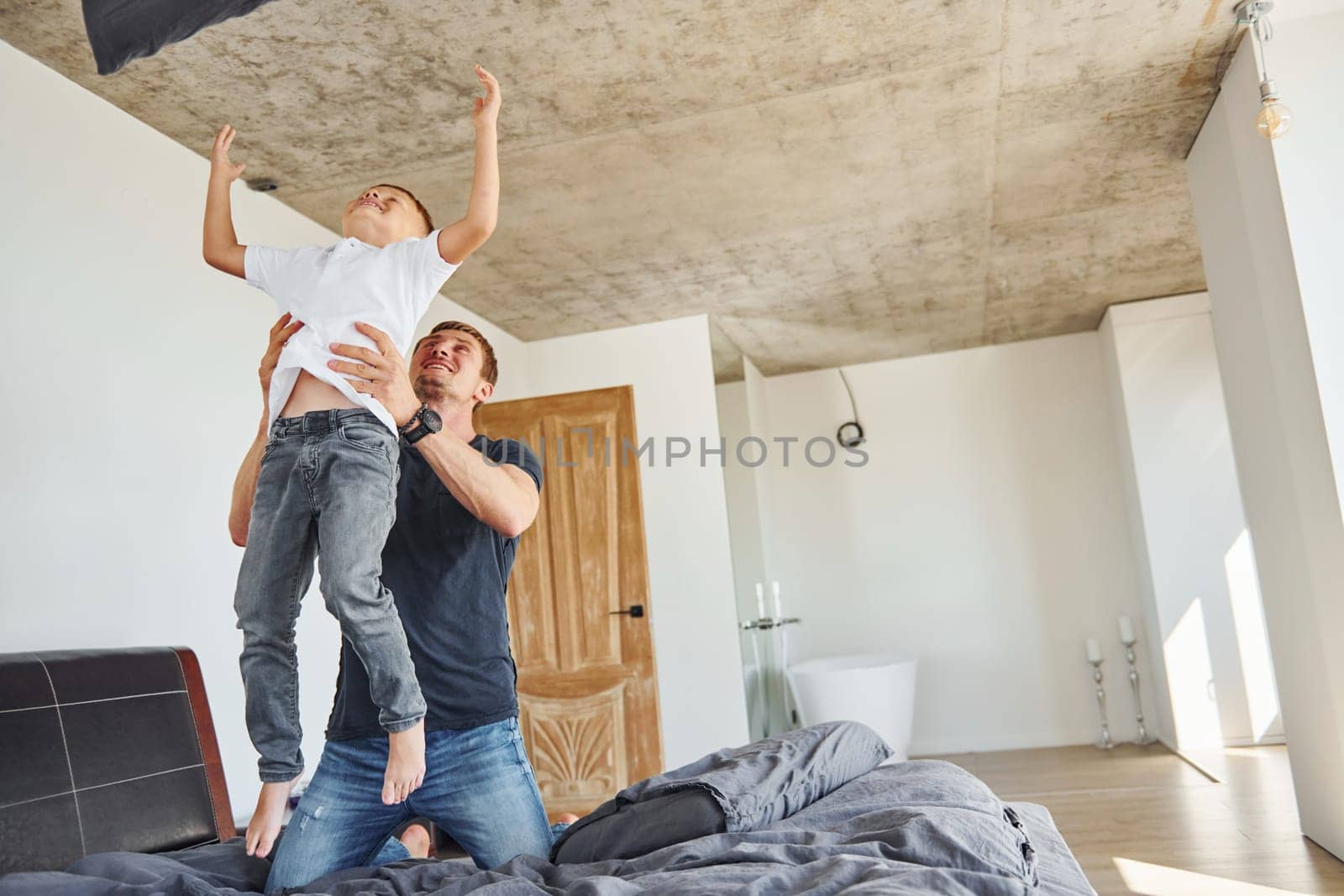 Active weekend time spending. Father and son is indoors at home together by Standret