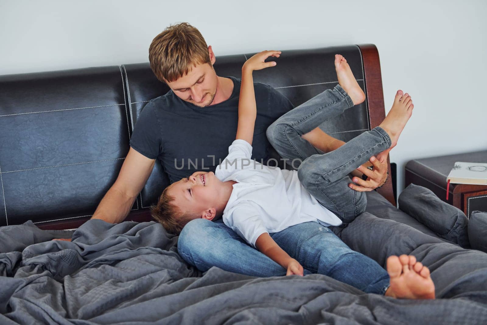 Father and son is indoors at home together by Standret