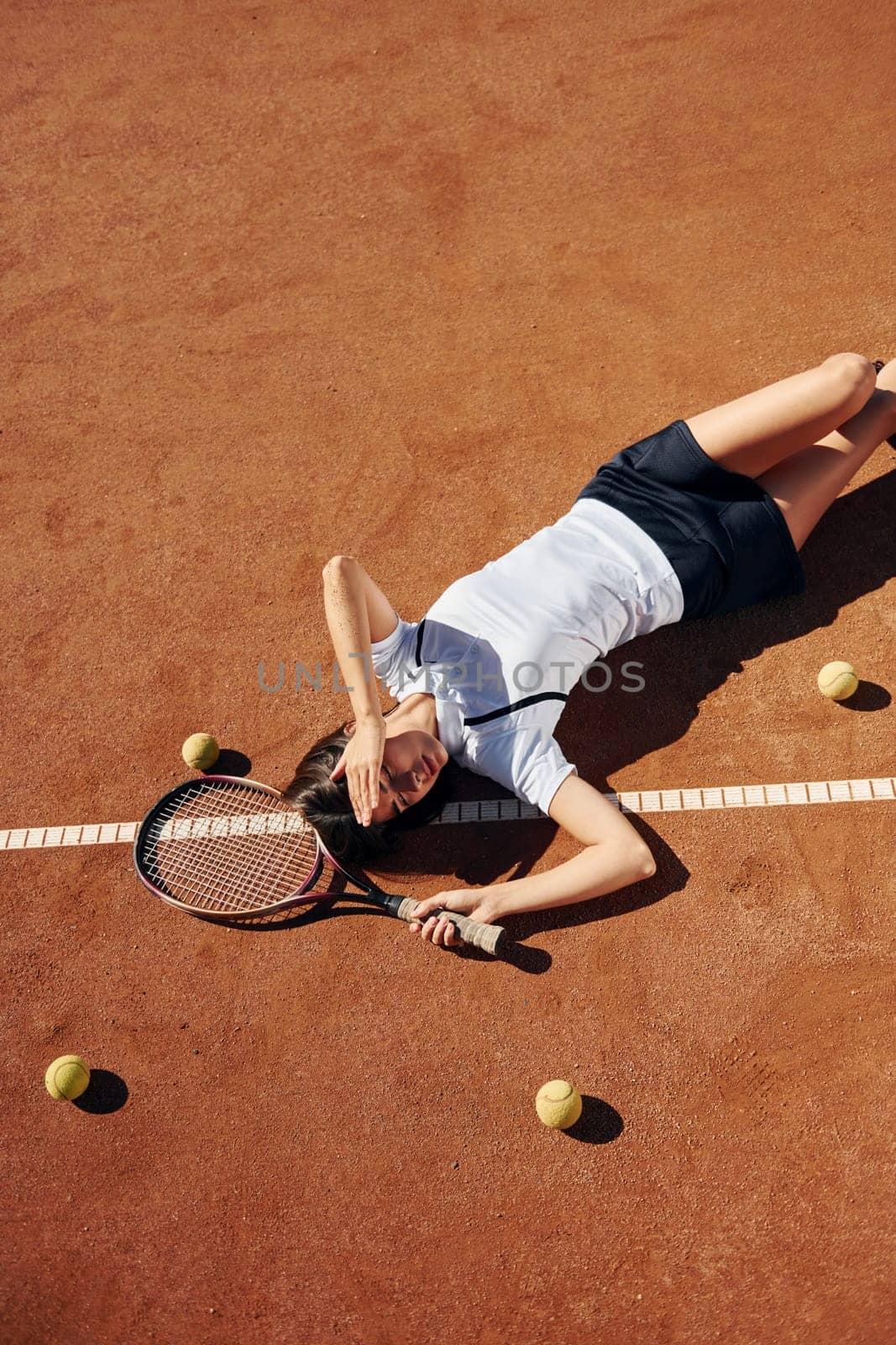 View from above. Female tennis player is on the court at daytime.