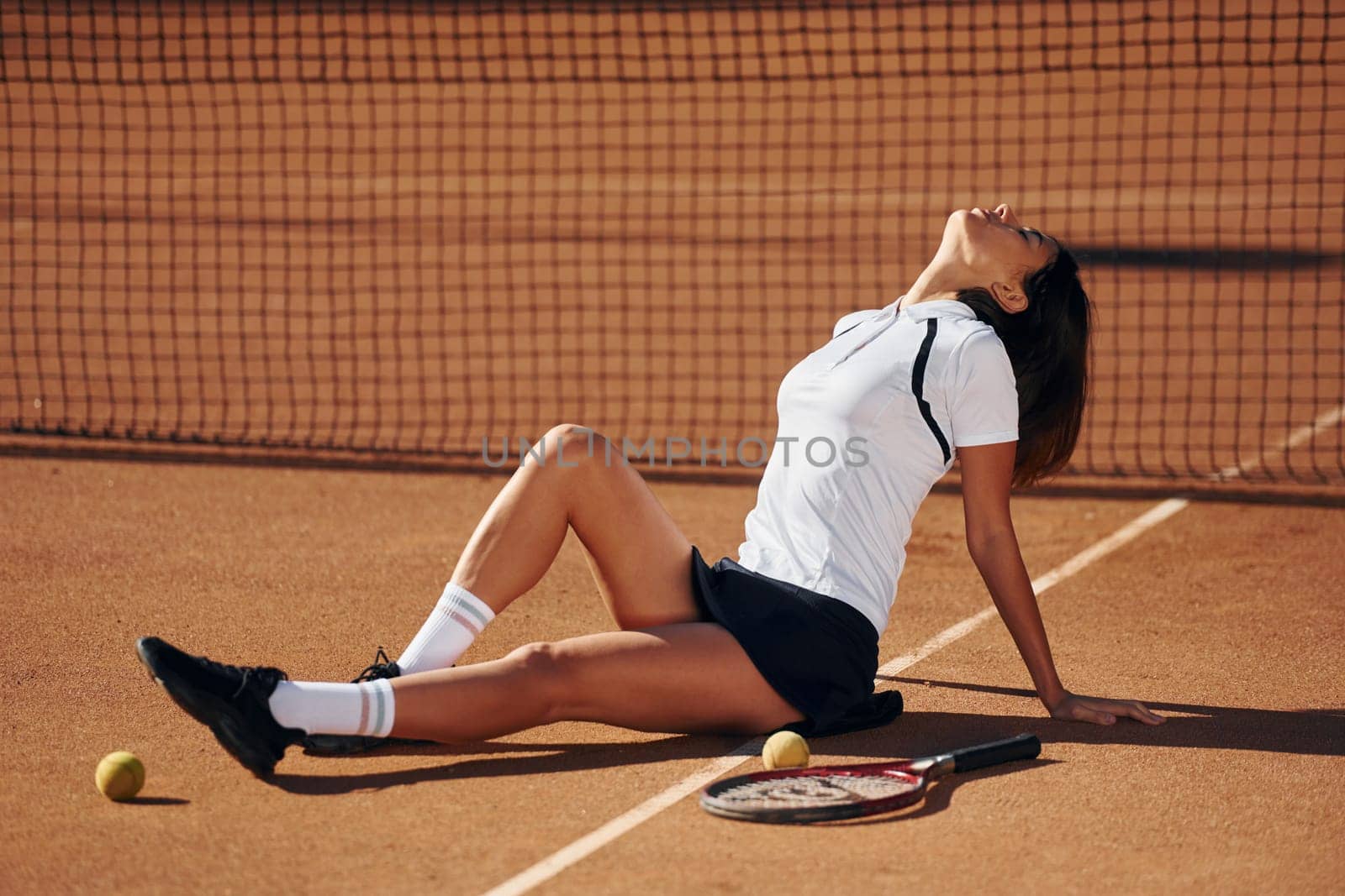 Enjoying the break. Female tennis player is on the court at daytime.