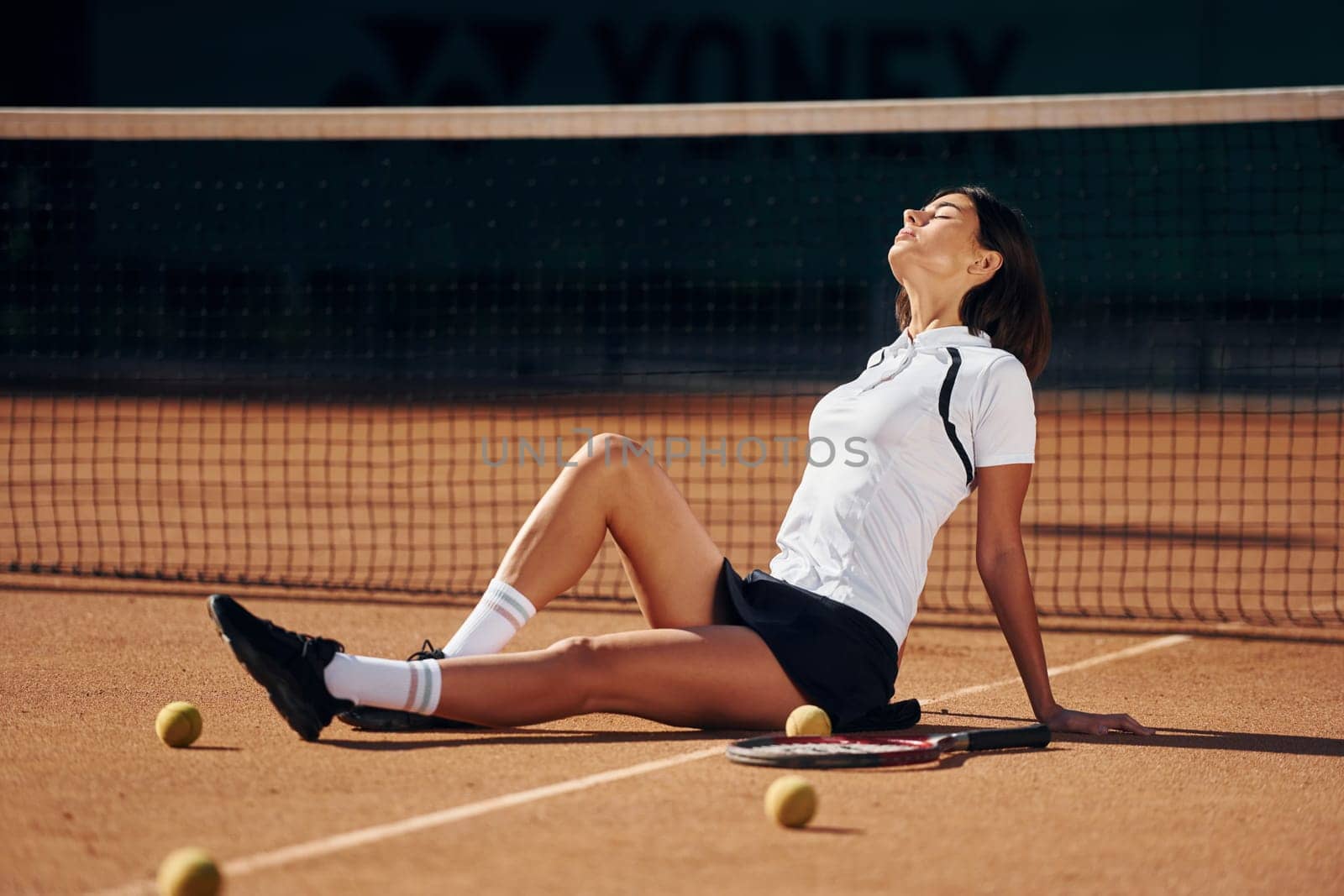 Enjoying the break. Female tennis player is on the court at daytime.