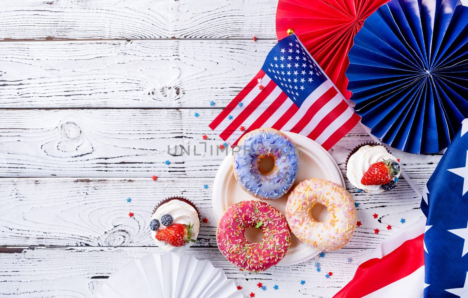 Sweet cupcakes and donuts with usa flag on wooden background by Desperada