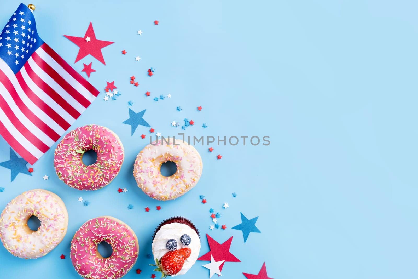 Fourth of july celebration. Sweet cupcakes and donuts with usa flag on blue background