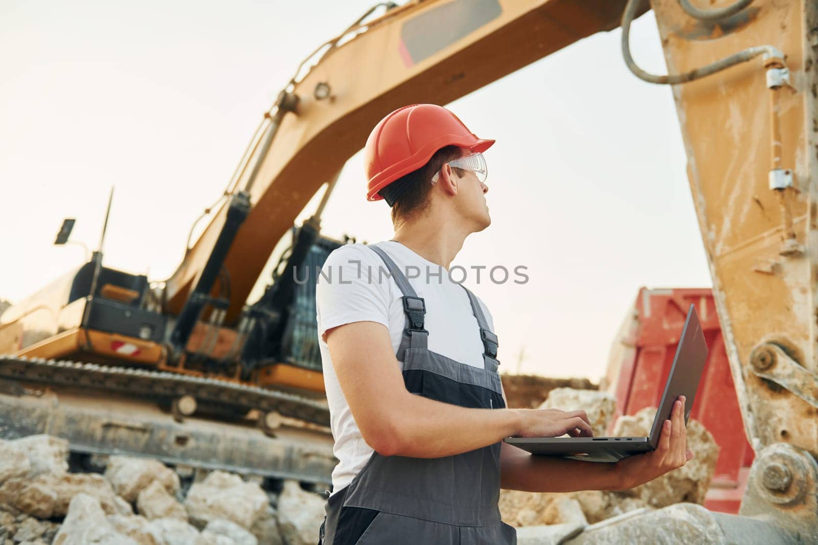 Busy day. Worker in professional uniform is on the borrow pit.