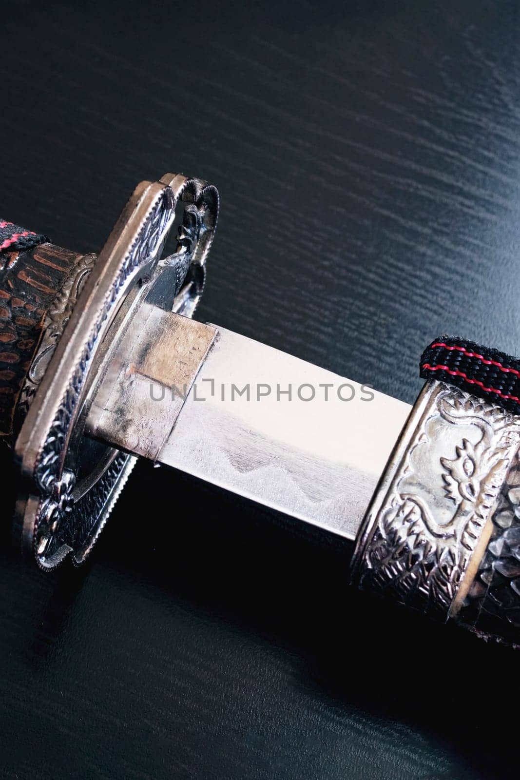 Samurai sword on a black wooden table close up