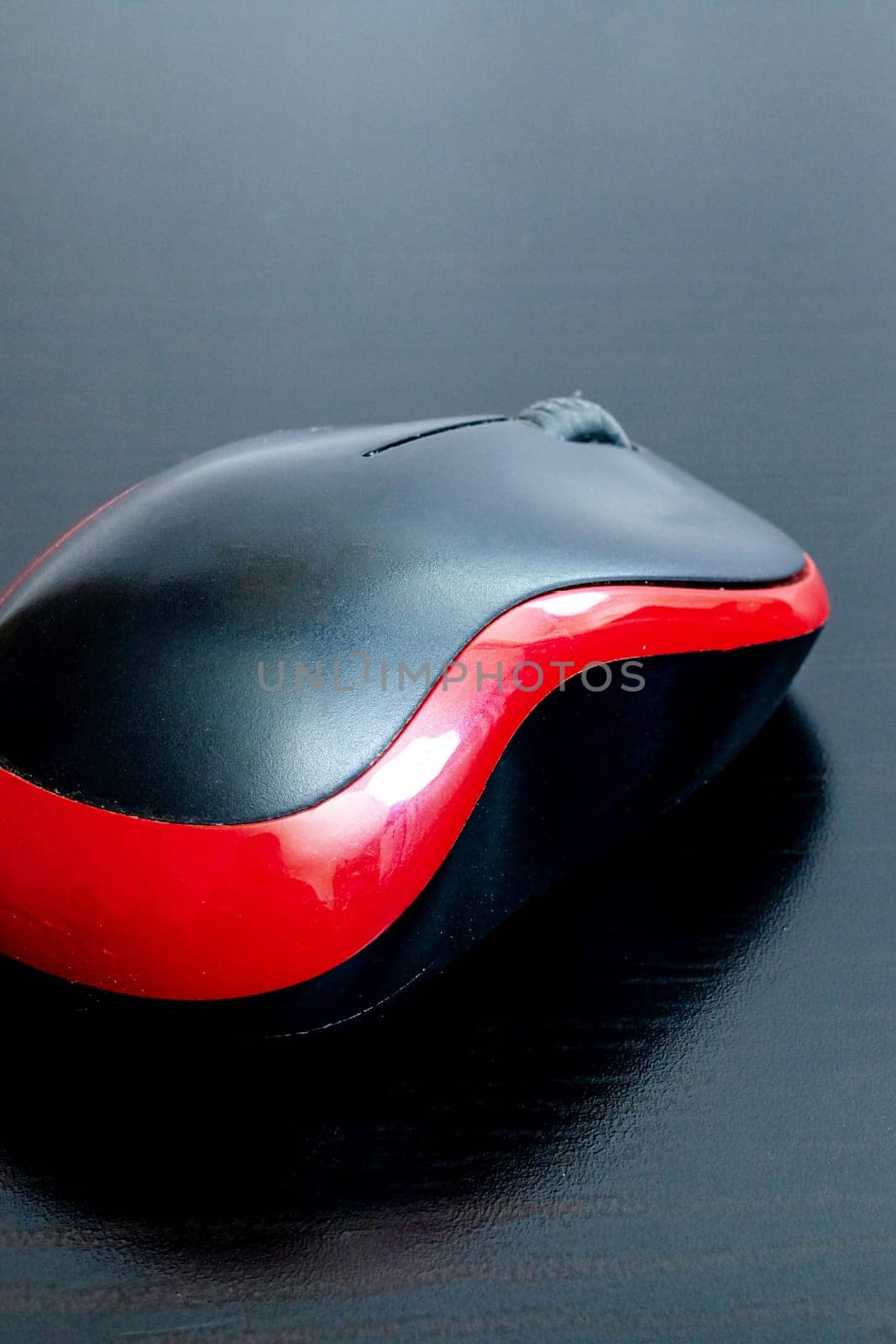 Black computer mouse on a wooden table, copy space