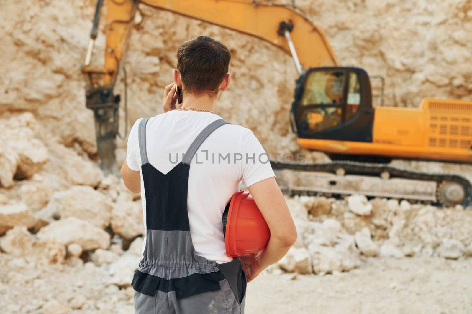 Operator is working on the borrow pit. Man in professional uniform.