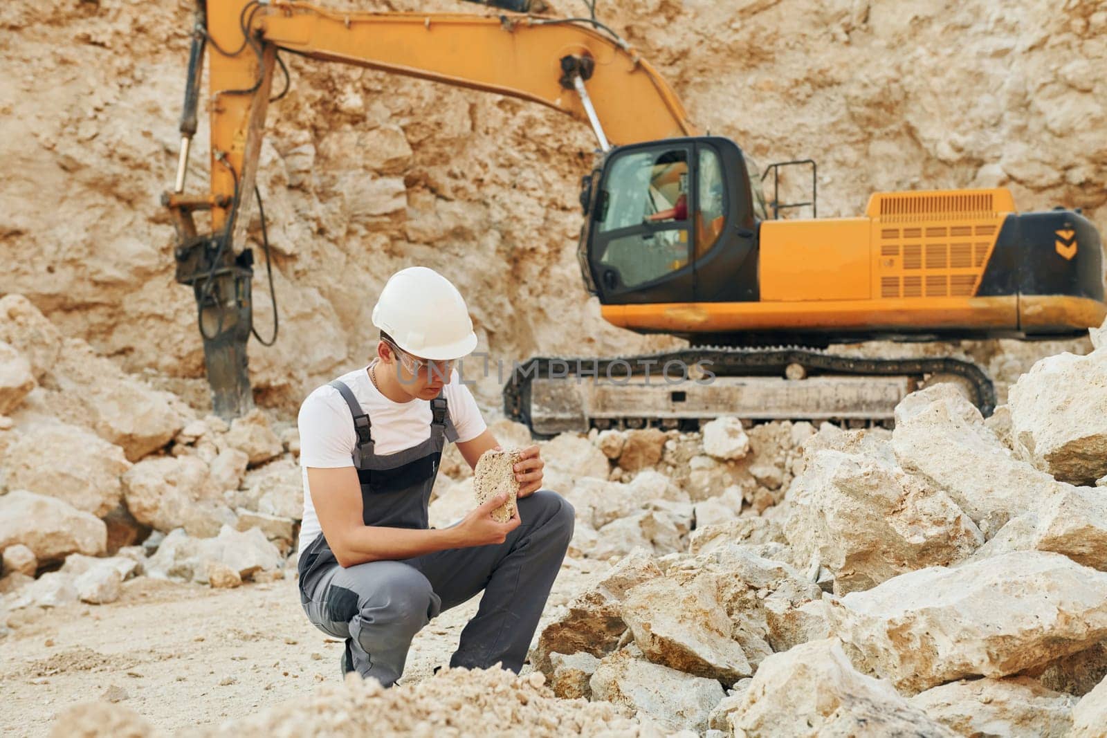 Operator is working on the borrow pit. Man in professional uniform.