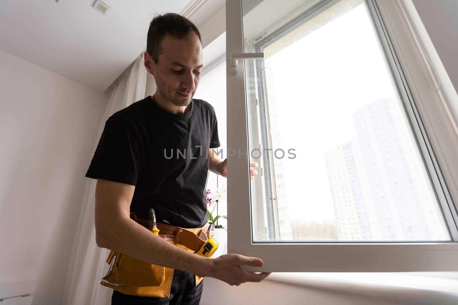 Worker in installing rubber seals on plastic upvc window. by Andelov13