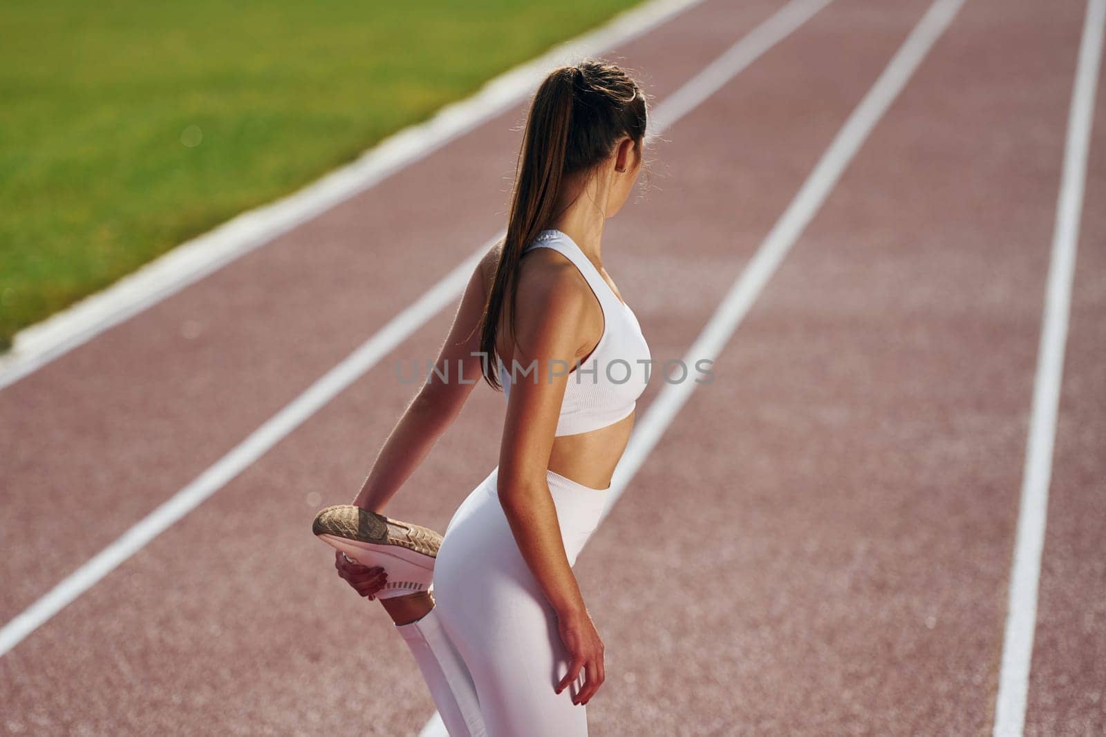 Conception of fitness. Young woman in sportive clothes is exercising outdoors.