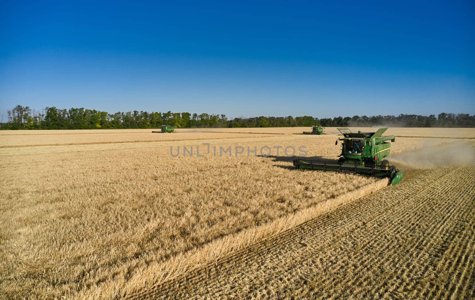 John Deere harvester works in the field. Combine Harvesting Wheat. Field field of cereals during harvesting. Modern equipment works. 07.07.22, Rostov region, Russia.