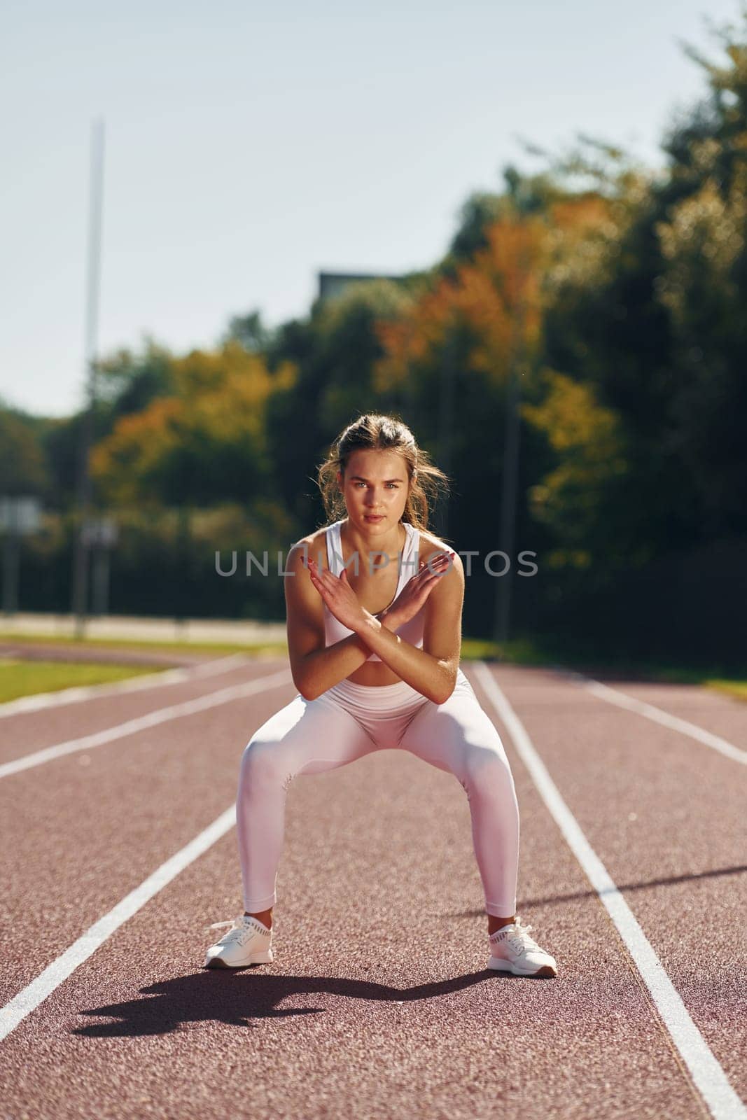 Photo in motion. Young woman in sportive clothes is exercising outdoors.